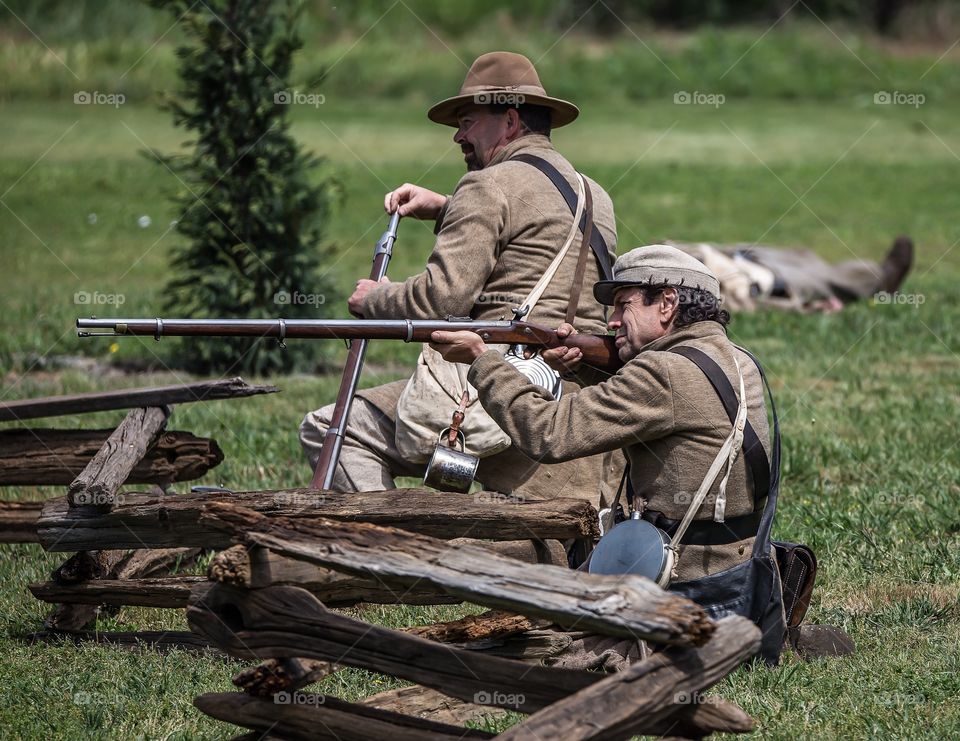Trying to Hold Them off. Confederate soldiers firing at Union troops during Civil War reenactment 