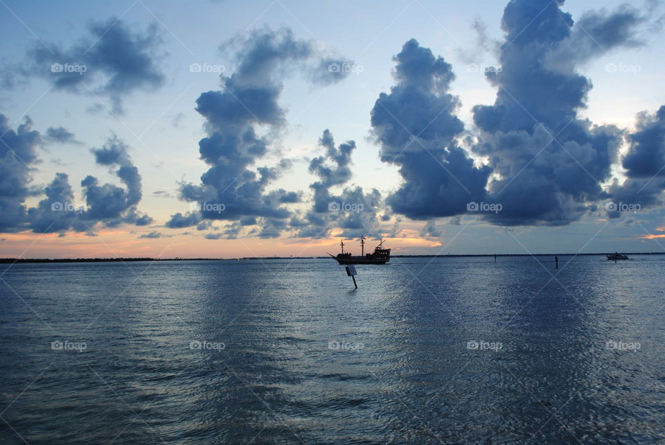 A boat in the ocean at sunset