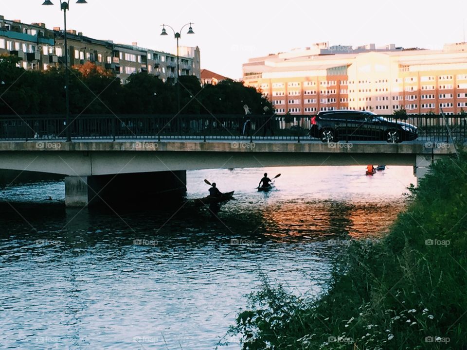 People Canoeing in the city under the bridge 