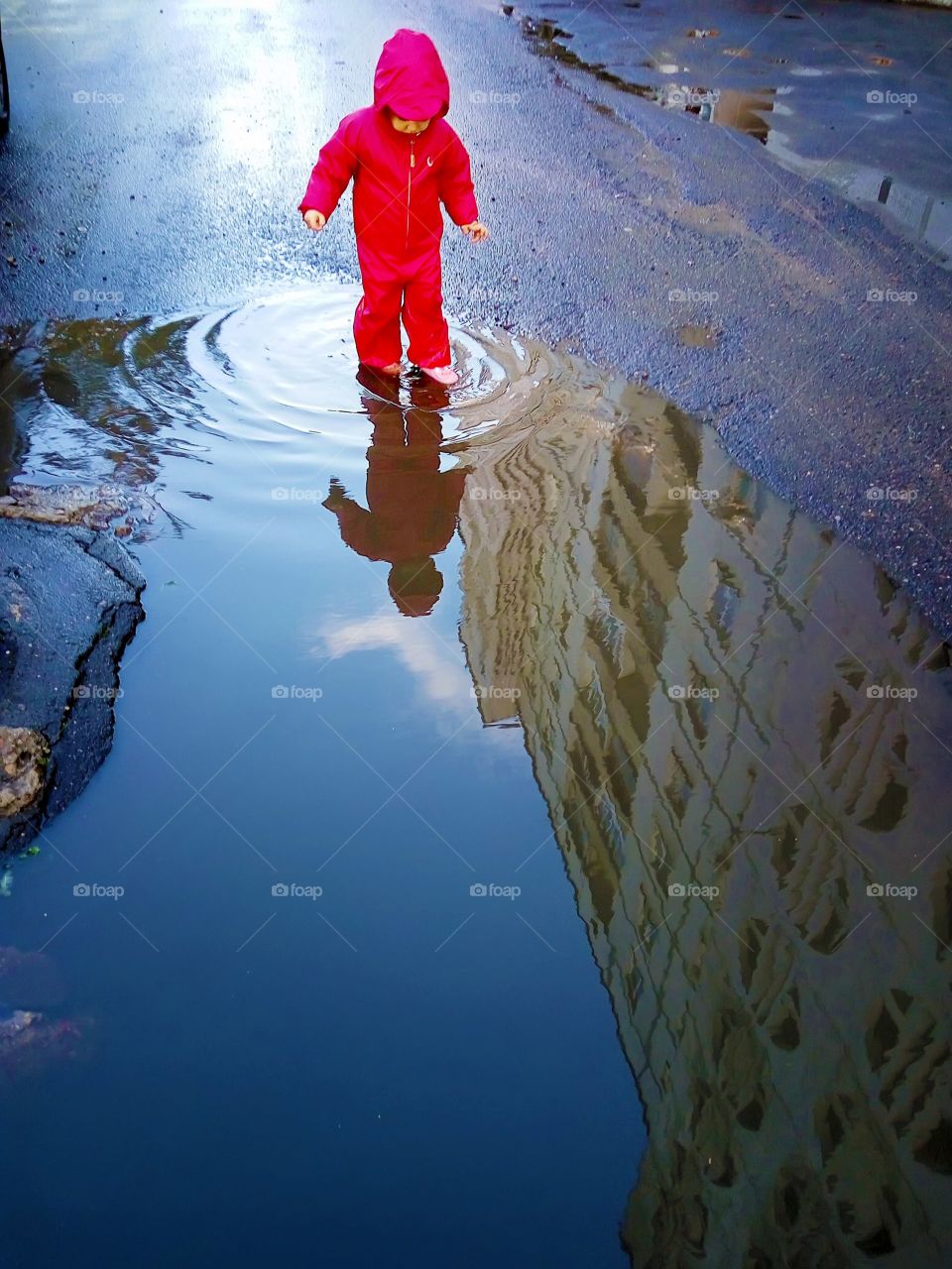 little girl reflection in the puddle
