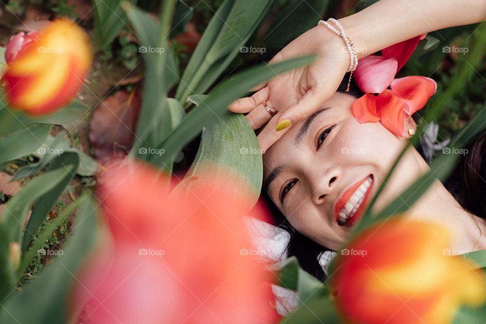 Happy asian woman smiling near tulip field 