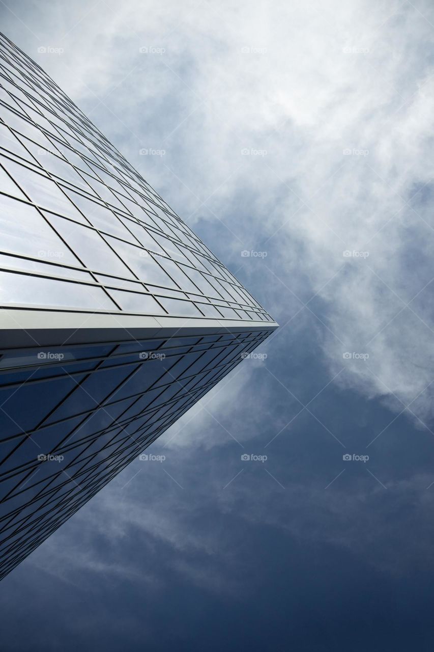 Abstract urban background .  Office  windows against clear blue sky . Vertical shot .