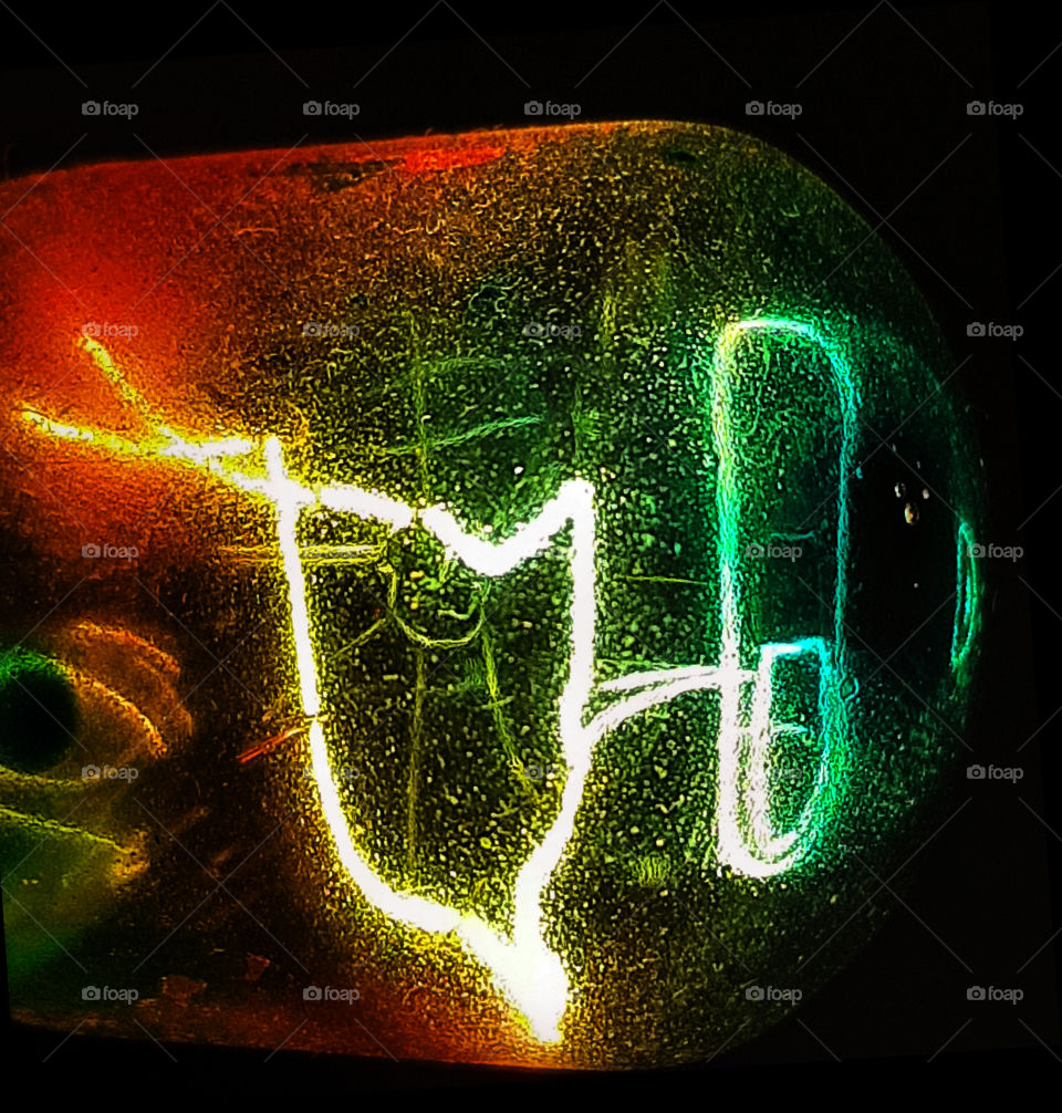 Closeup photo of glowing element in the small light bulb, showing hot wire glow by electric current flowing in the tungsten filament.