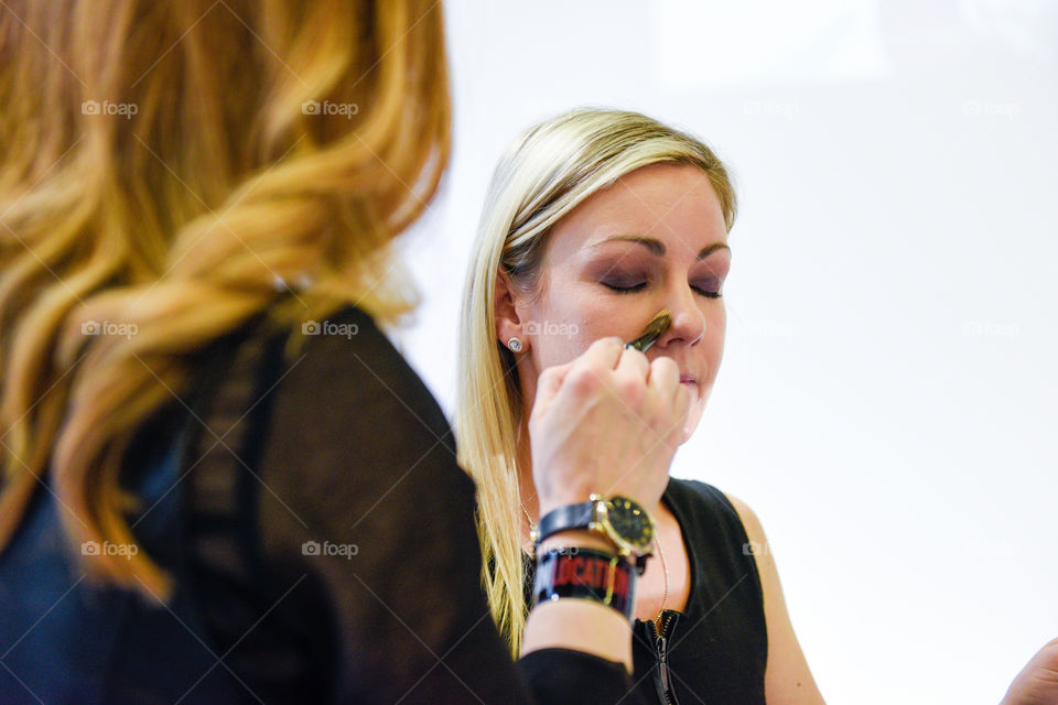 A woman gets a makeover in a makeup studio in London.