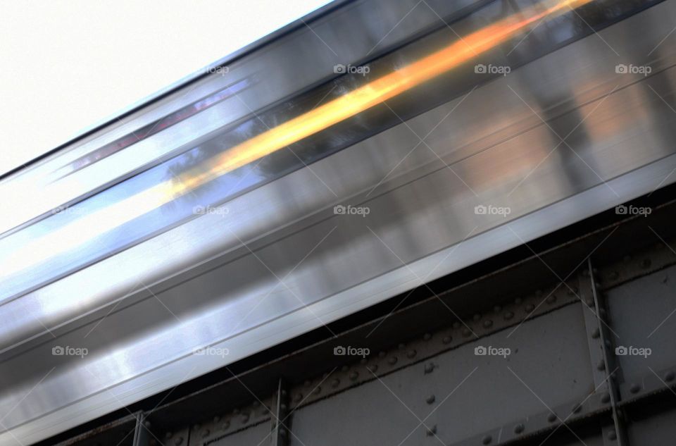 A commuter train passes through a train station at the height of rush hour on an elevated track.