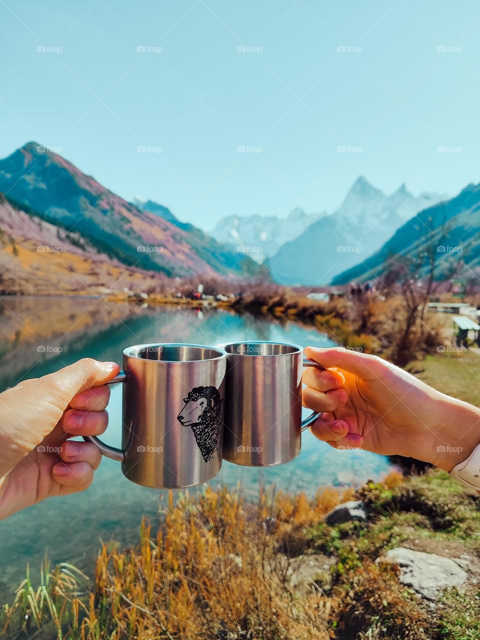 Two mugs on the background of a mountain lake