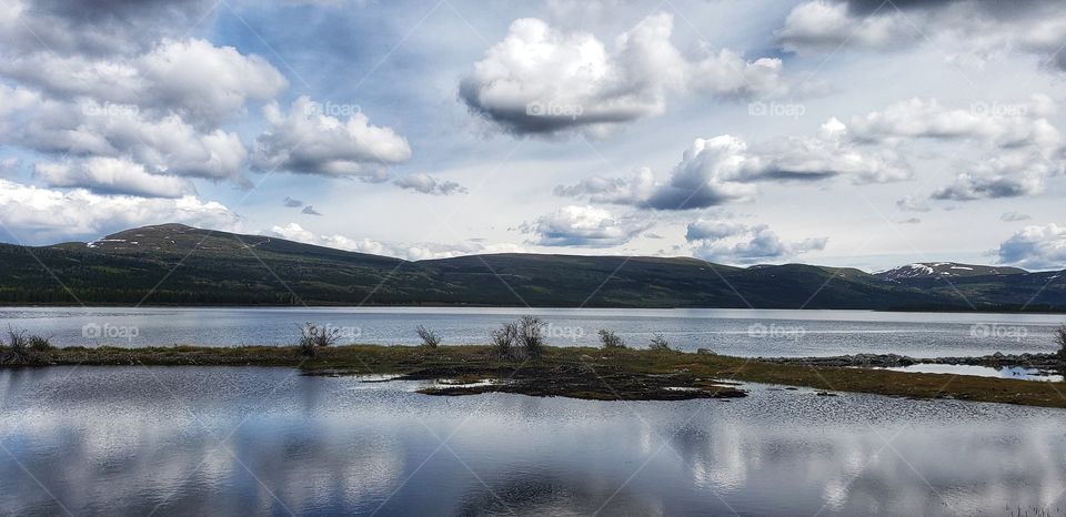 Fluffy cloud reflections on a still lake