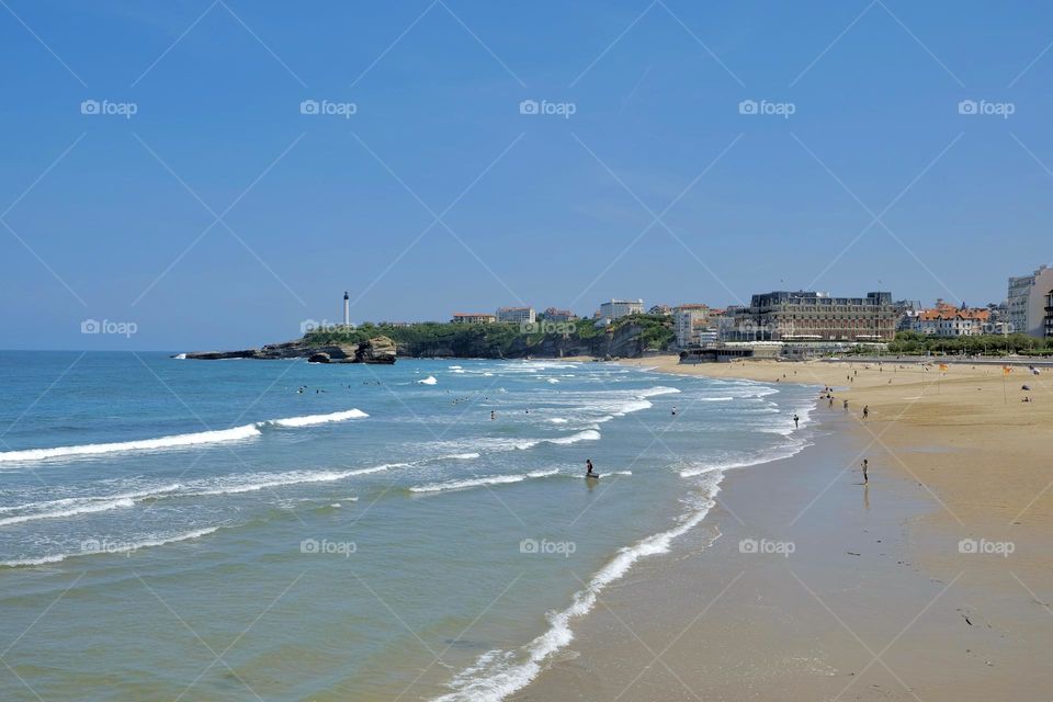 Scenic view of beach against clear blue sky. 