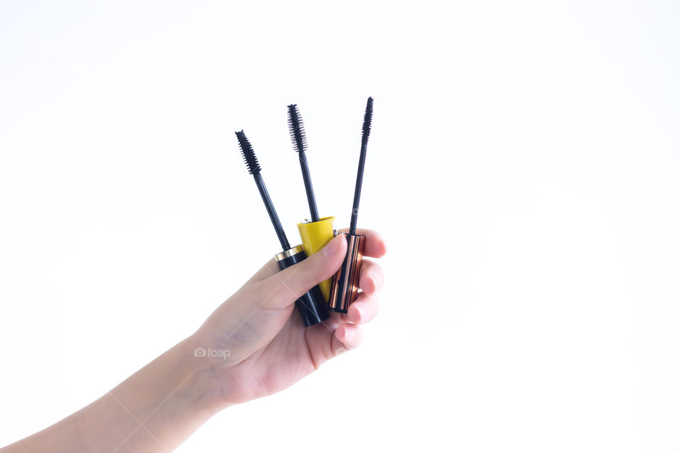 Hands holding mascara