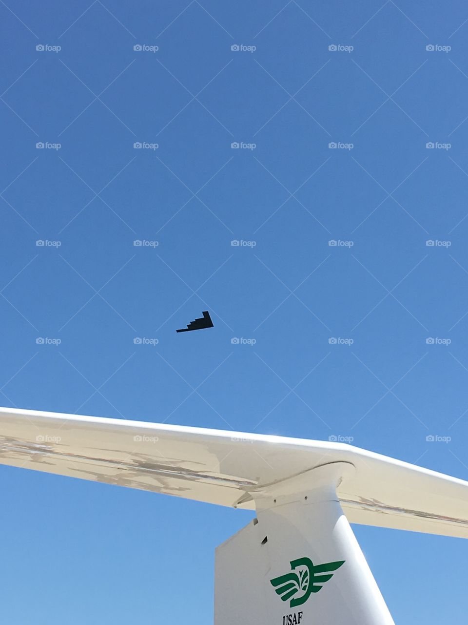B2 above the tail of a small trainer plane