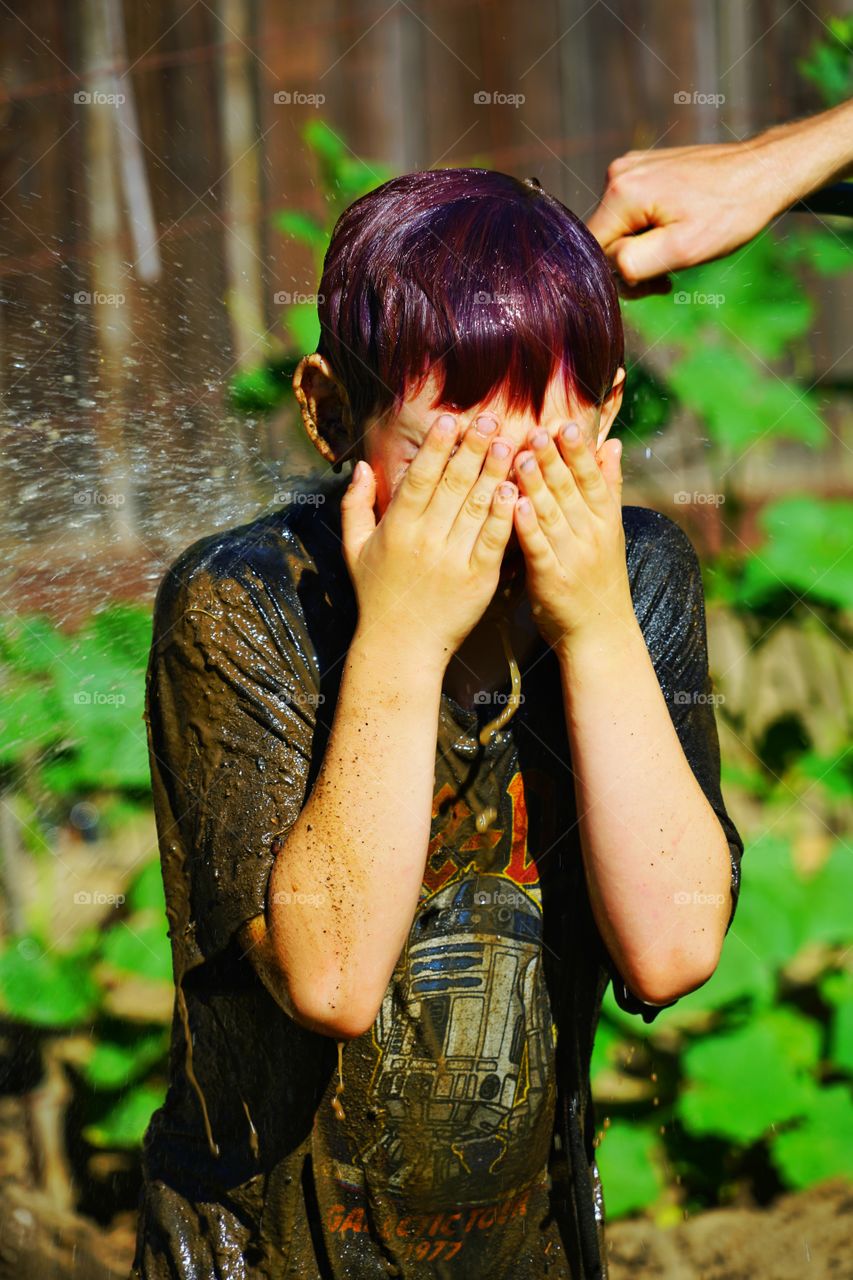 Boy Being Sprayed With Water