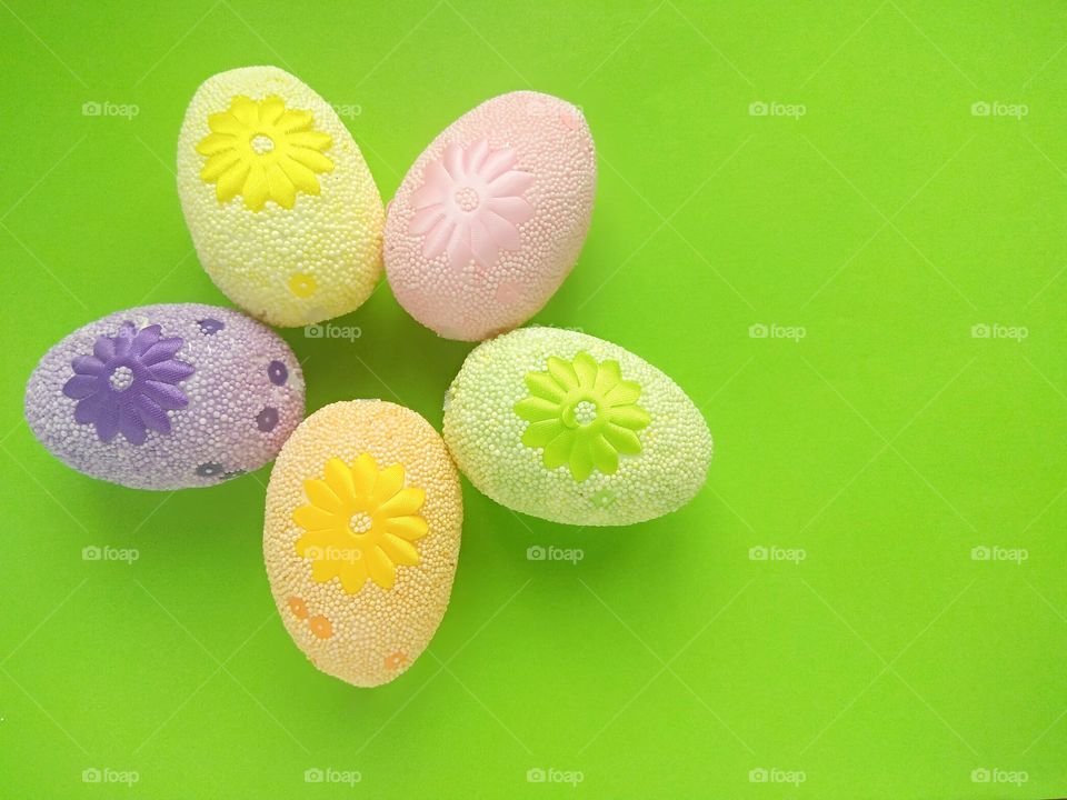 Five colorful easter eggs on a green background