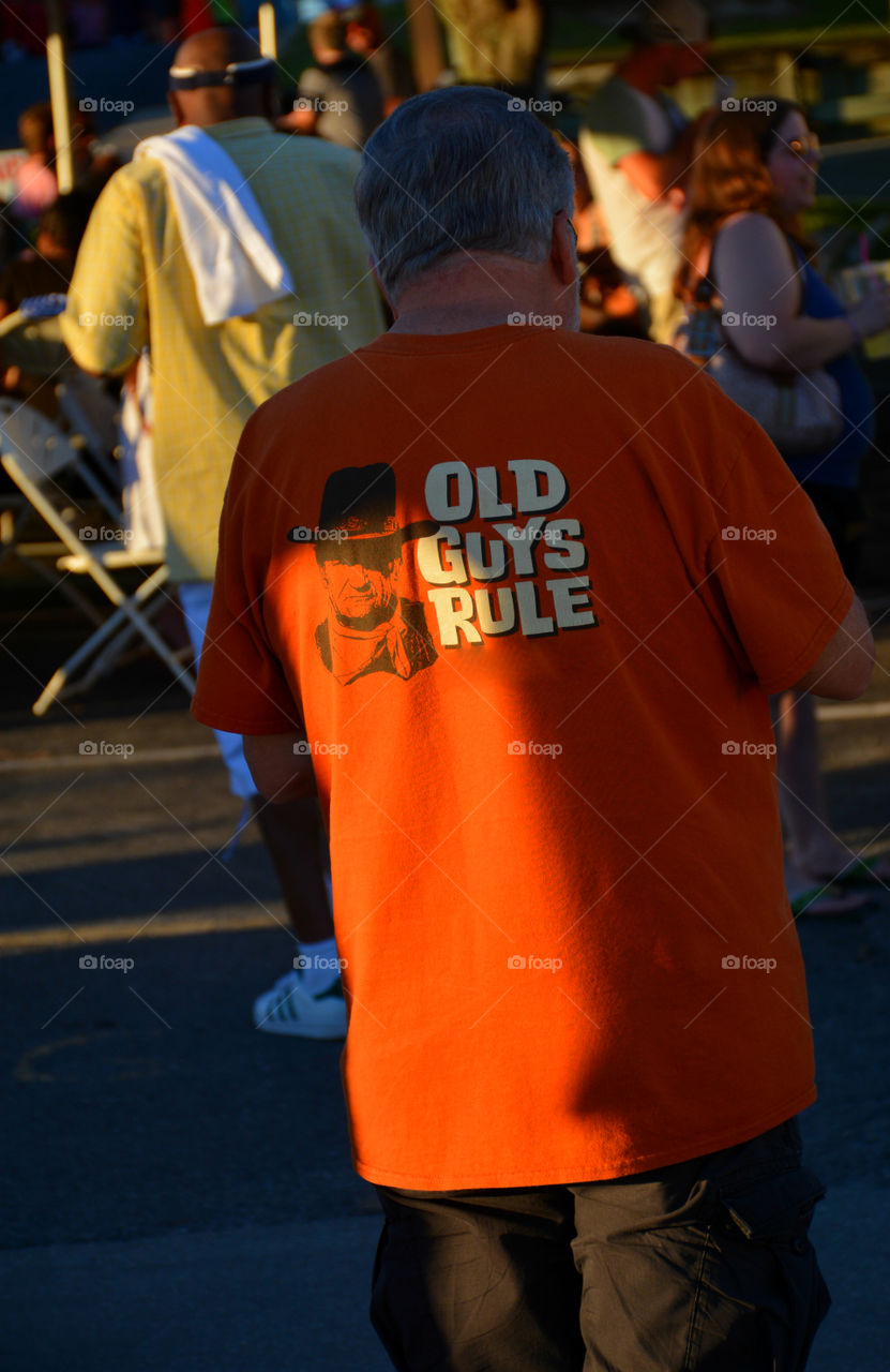 An elderly man show he's proud to be old by displaying it on his T-shirt!