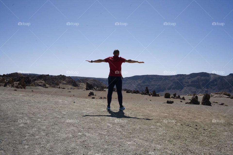 man with outstretched arms in the mountains