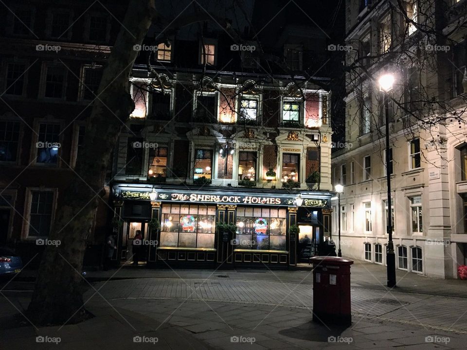 Lights on in the windows of a London pub 