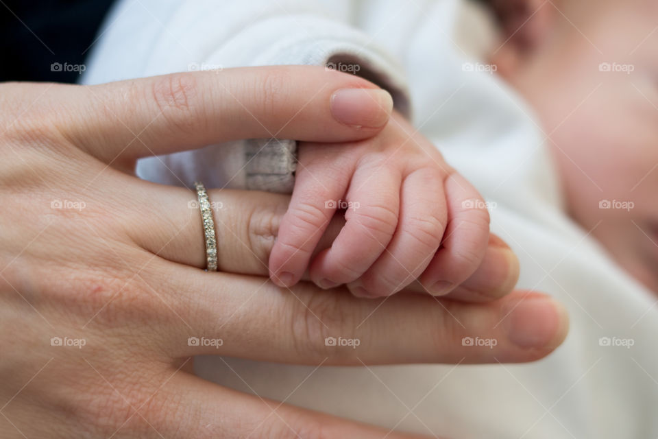 Baby holding mother's hand