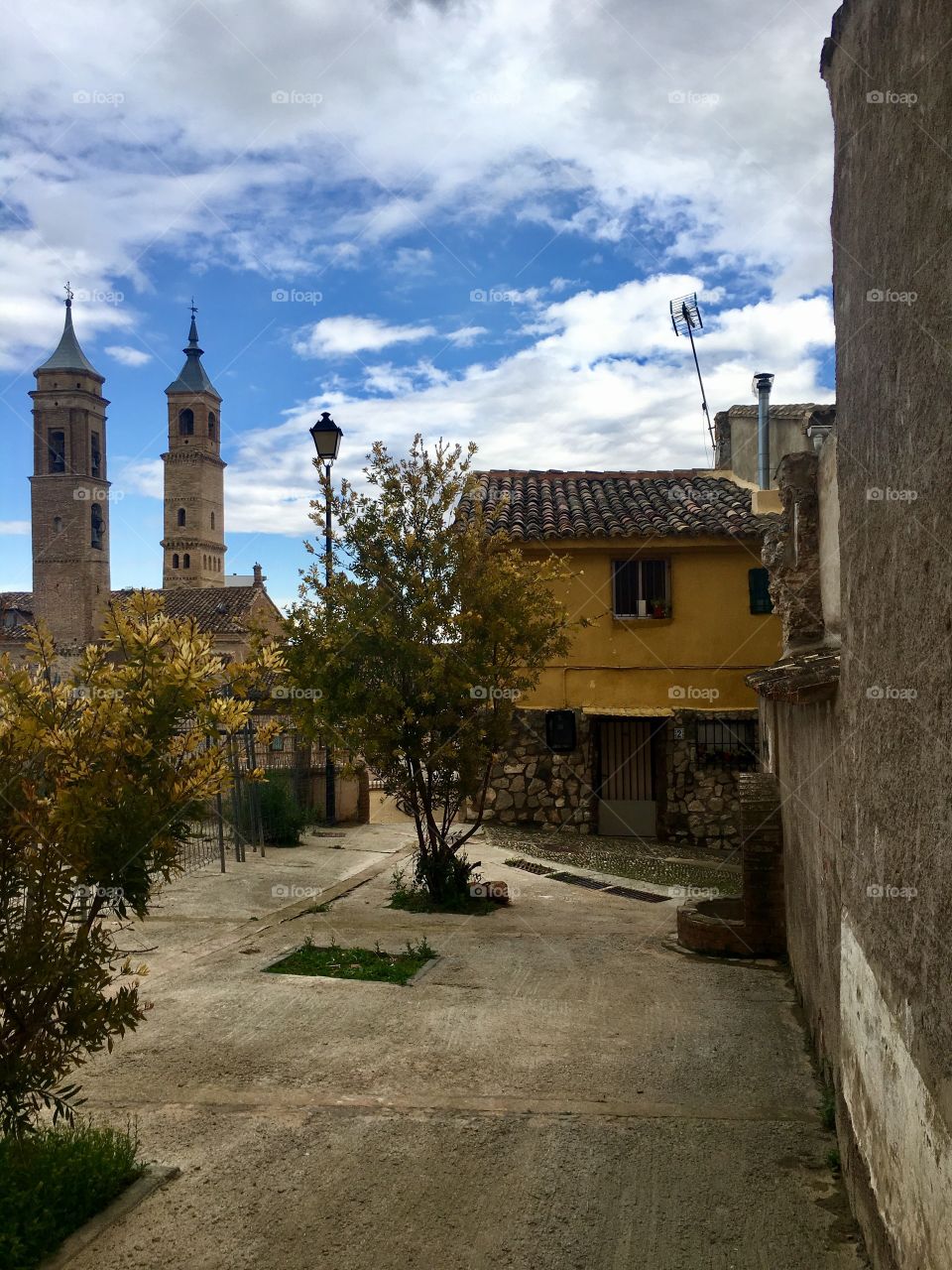 Colorful plaza of a beautiful European village with spires of the cathedral in the background. 