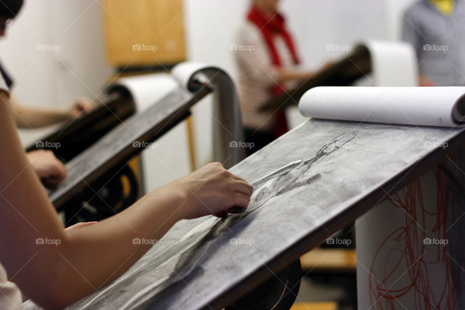 An artist sketches in charcoal in the studio