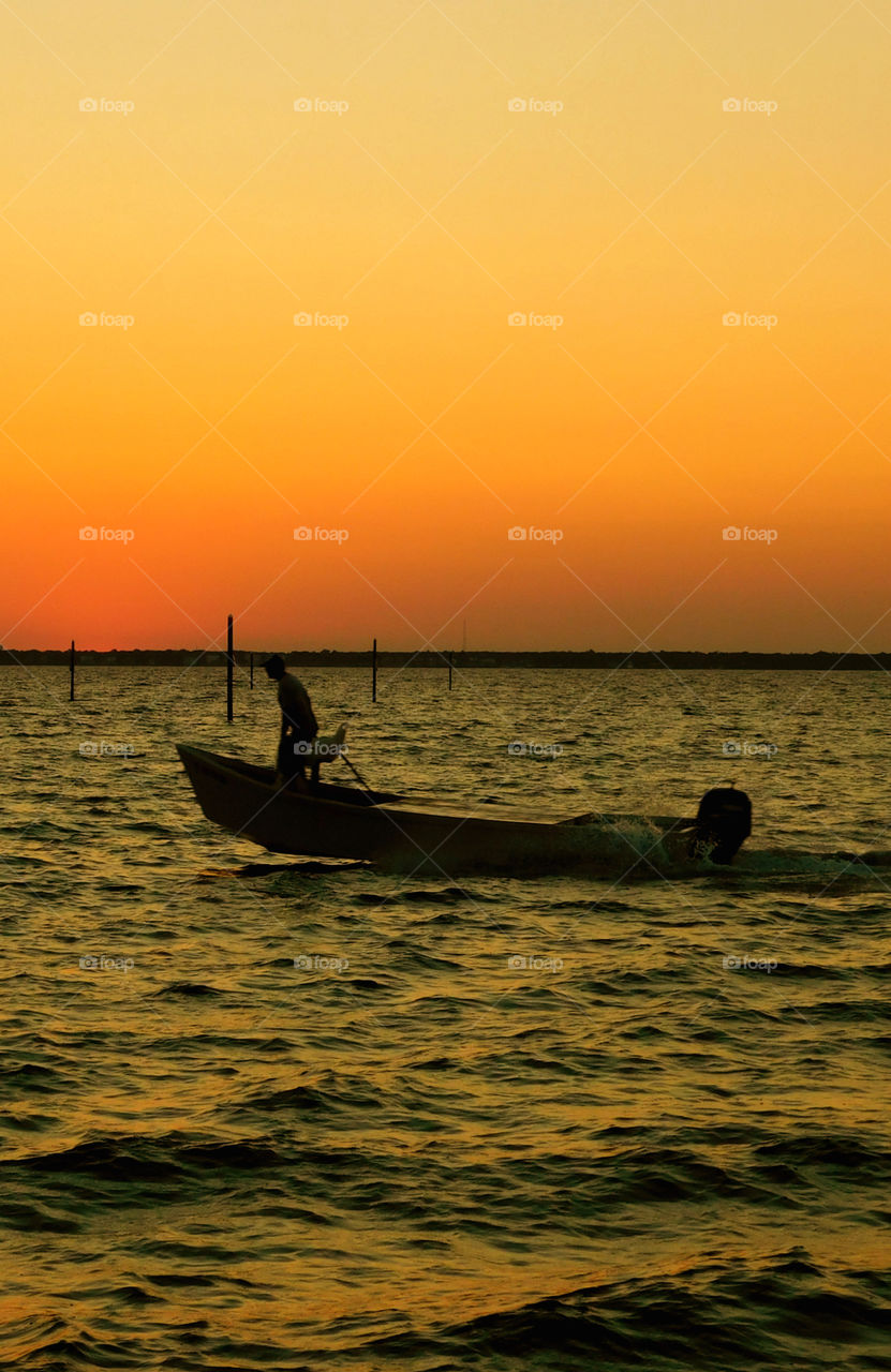 Silhouette of a boat in the sea at sunset