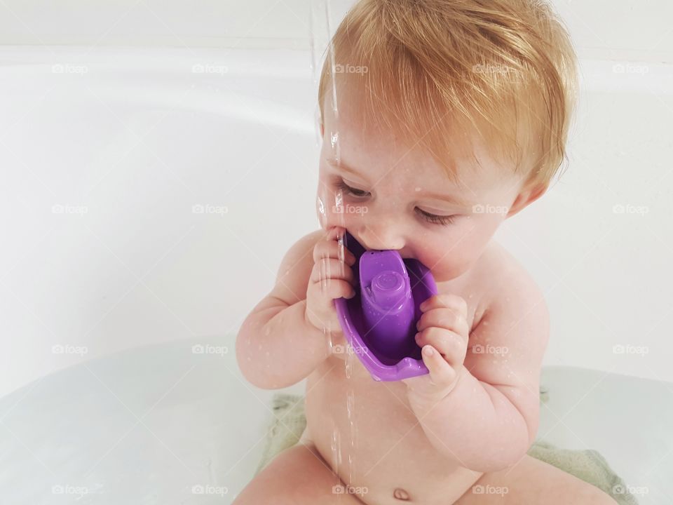 Baby in bath playing fun bathtime purple boat