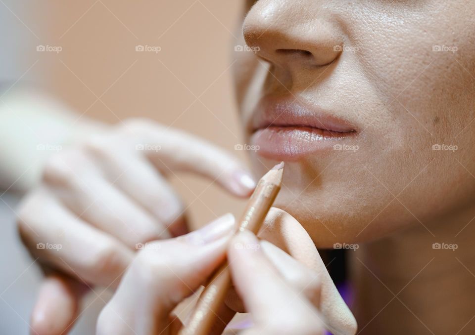 Makeup artist applies makeup to a woman.  Work in a beauty salon.  Professional cosmetics