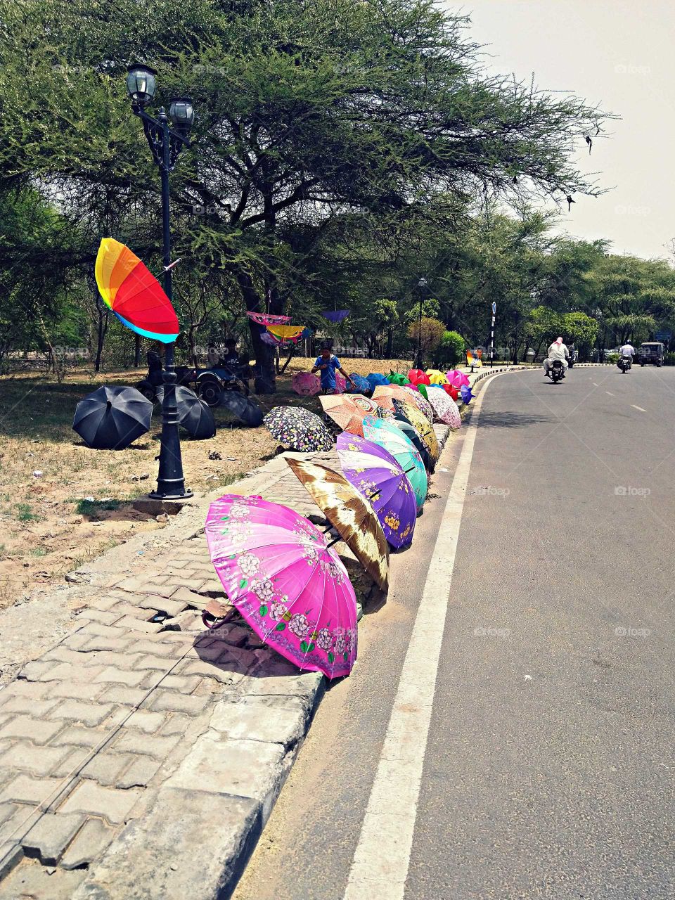 Colorful umbrellas are selling on the road