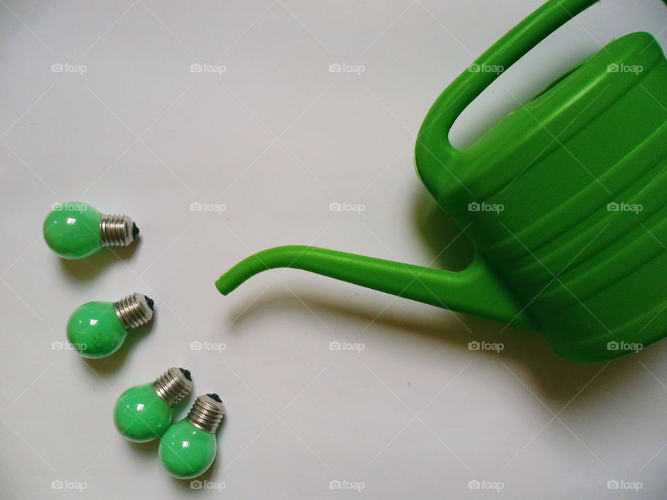 Green light bulbs and a green watering can