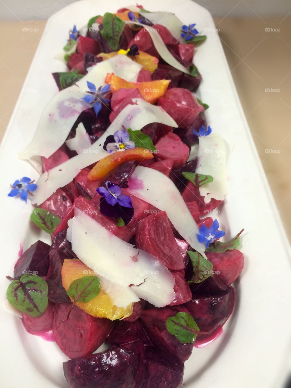 Beet salad tossed in citrus vinegrette with orange slices and shaved asiago cheese. Garnished with sorrel and flowers.
