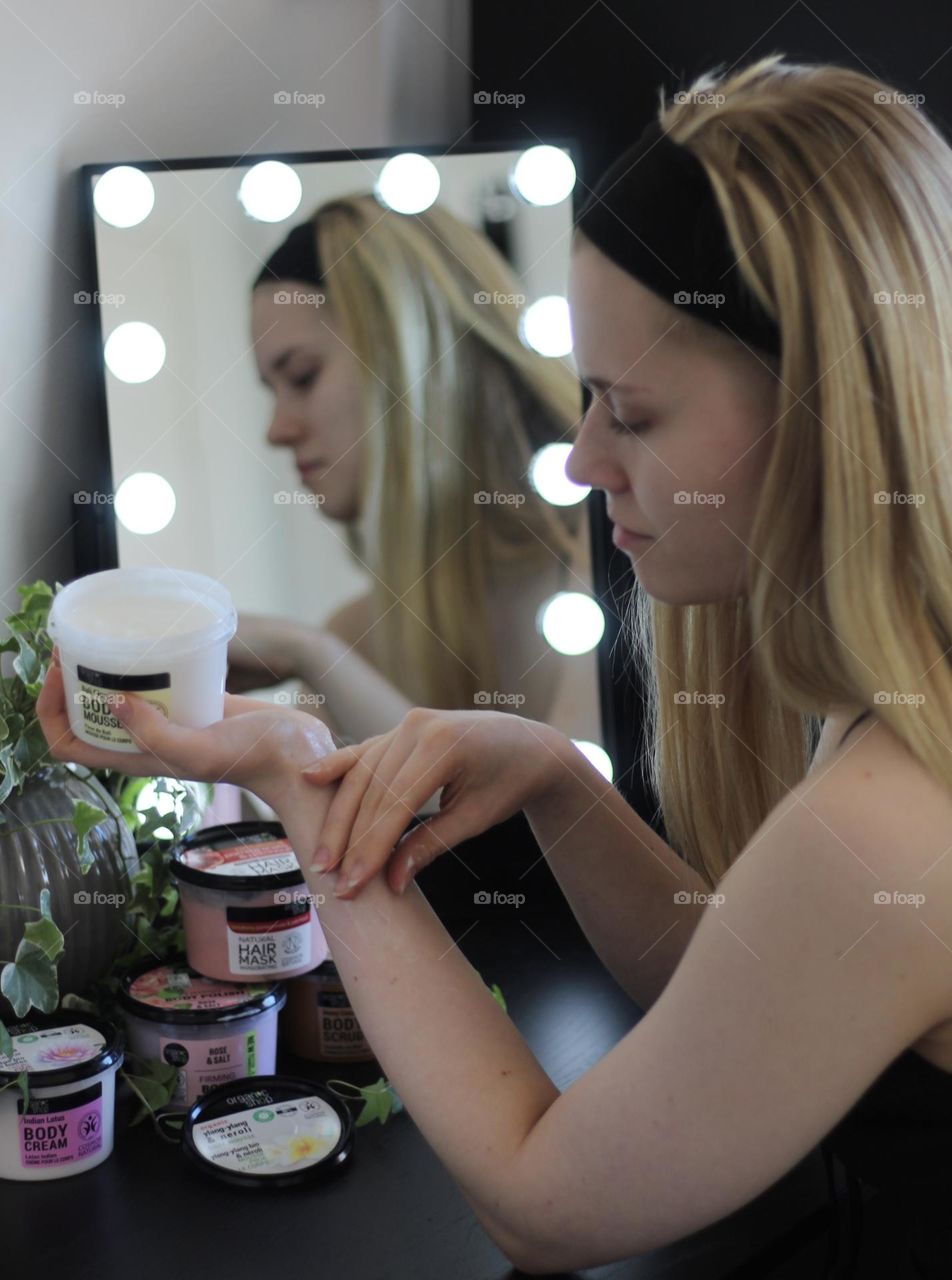 Girl applying moisturizer on her skin