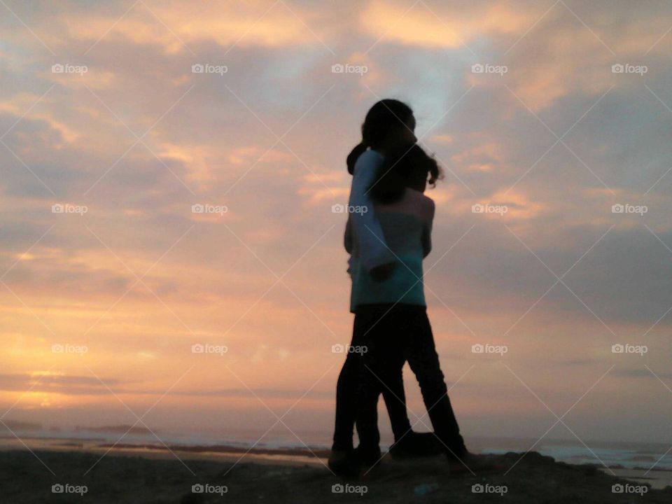 Two girlfriends standing against magic sunset at essaouira city in Morocco.