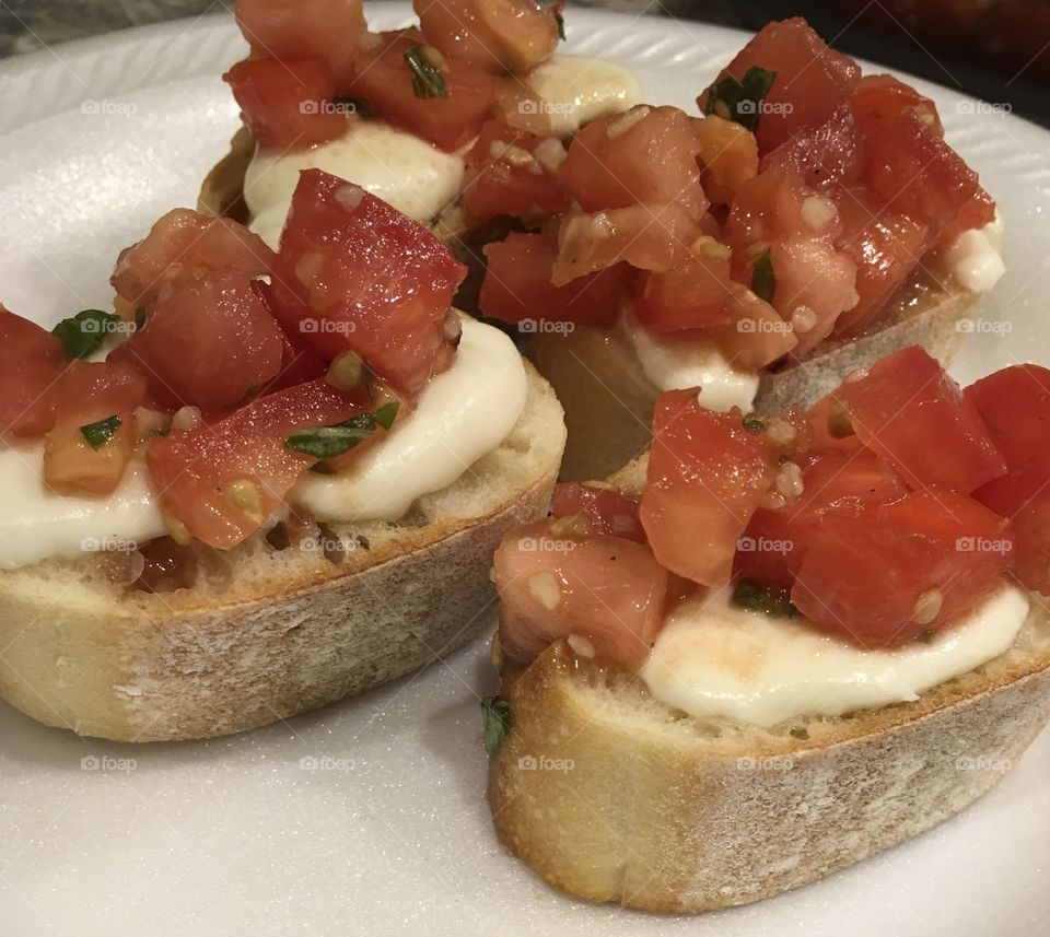 Delicious homemade Bruschetta on French bread with melted cheese 
