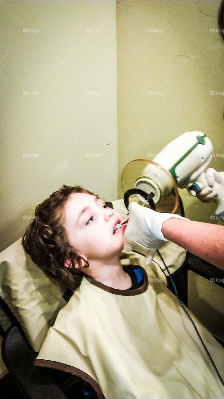 boy getting xrayed at dentist