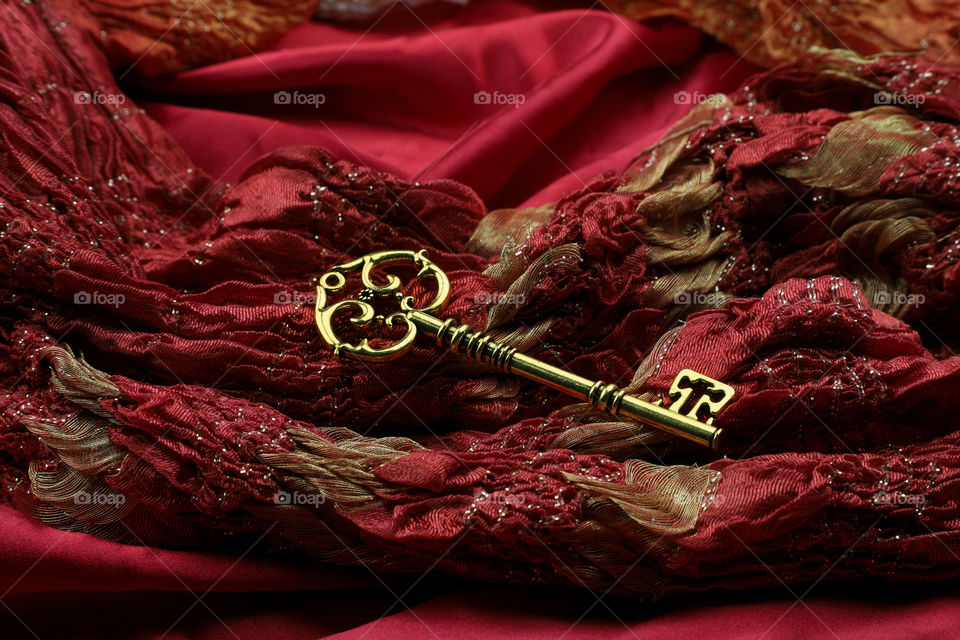 Golden vintage luxury key on red royal luxurious fabric