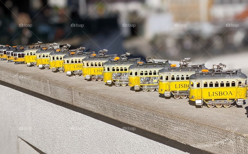 collection of yellow trains on a slate wall in lisboa.