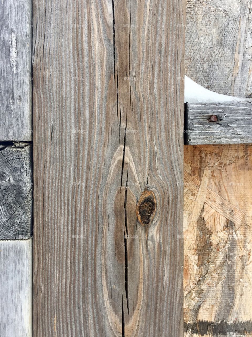 Abstract closeup of various grades of lumber on an outdoor structure in winter