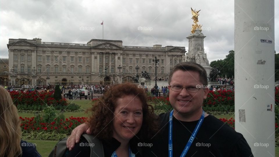 Man and woman standing in front of Buckingham palace, London