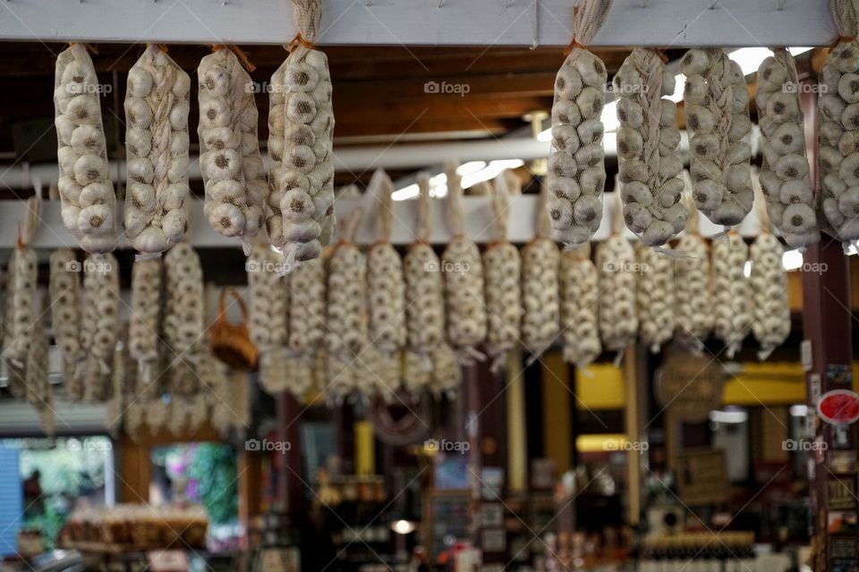 Garlic Cloves Hanging On Display In A Market