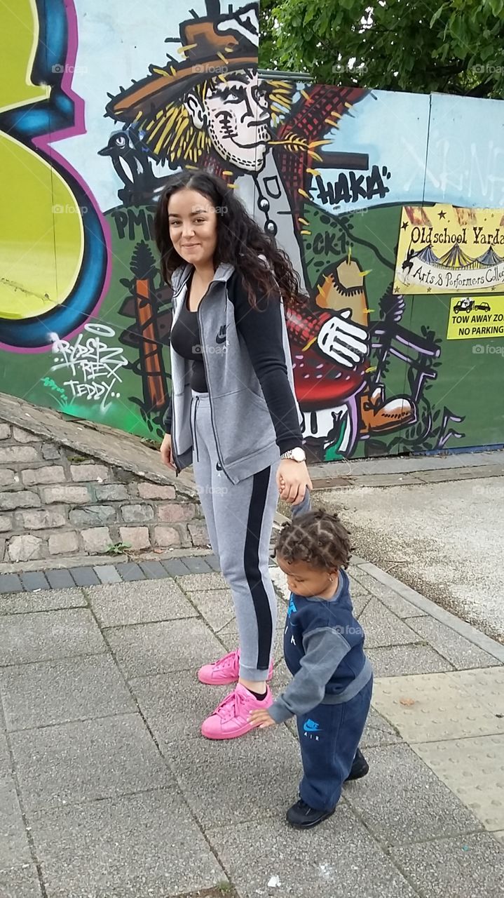 Smiling young Mother Walking away with her Child