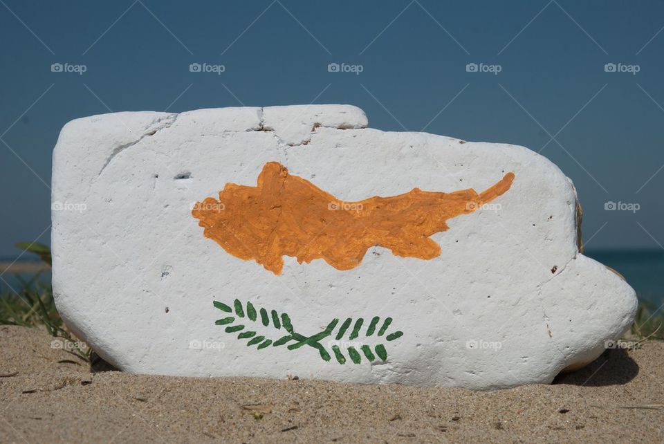 Cyprus flag on a stone over the sand