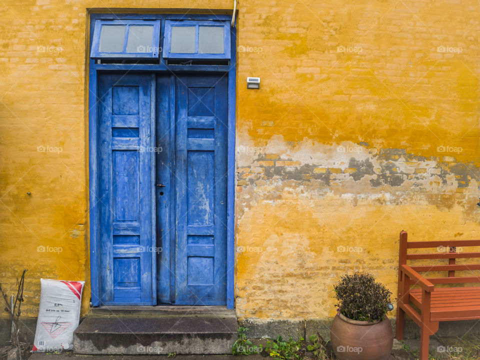 Old blue door in yellow wall,  vintage