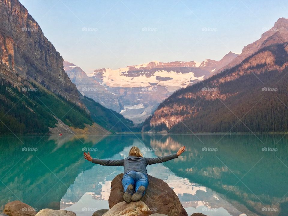 Yes you can fly!
Woman with arms outstretched as if flying soaring across beautiful turquoise Lake Louise in Canada's Rocky Mountains 