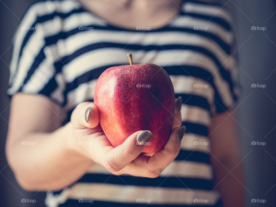 Single hand holding an apple