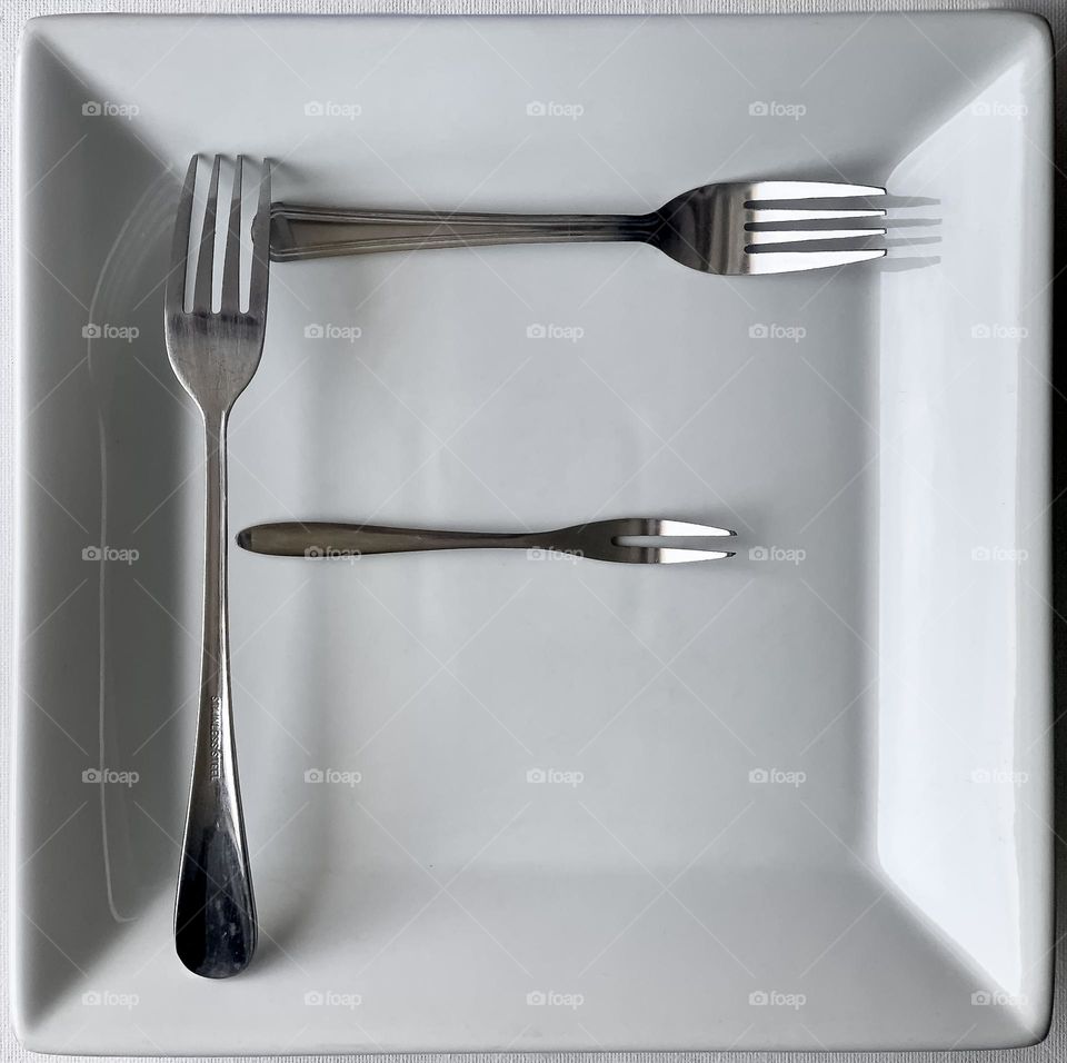 F is for Fork - an assortment of forks in the shape of a letter F on a square, white dinner plate