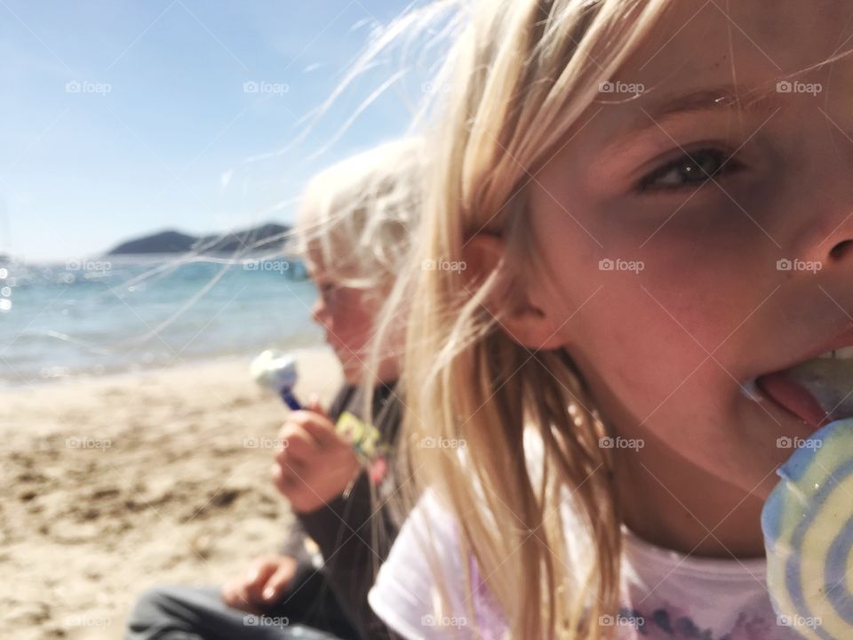 Close-up of a girl eating candy at beach