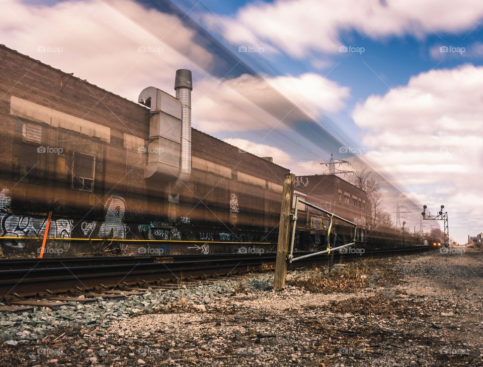 Motion blur from from a train going through the scene in a graffiti filled area.
