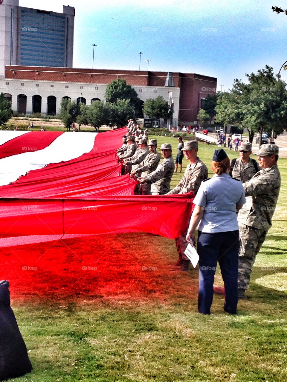 Proud to be an American . Soldiers holding a giant American flag at a 4th of July celebration
