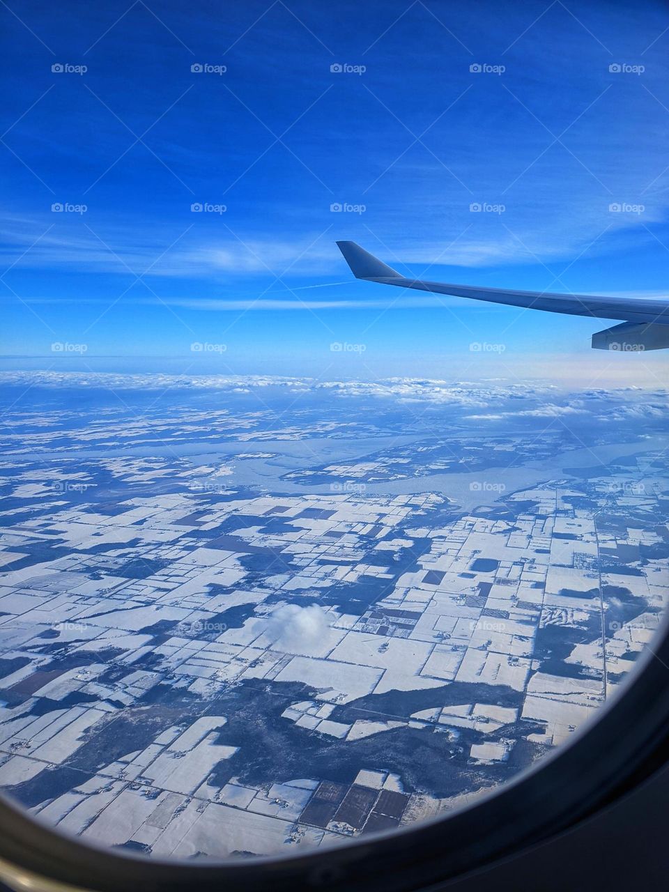 Sky view from the airplane close up. Fields and blue sky. Geometric shapes