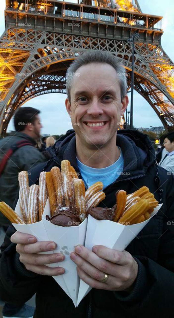 man with tasty churros and chocolate at
Eiffle tower, at dusk illuminated, Paris, France, eu, Europe
A churro is a fried-dough pastry—predominantly choux—based snack. Churros are popular in Spain, Portugal, France, the Philippines, Ibero-America and the Southwestern United States. In Spain, churros can either be thin (and sometimes knotted) or long and thick. They are normally eaten for breakfast dipped in champurrado, hot chocolate, dulce de leche or café con leche
