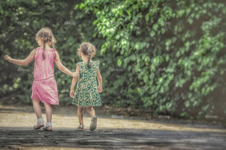 Two girls walking away from camera