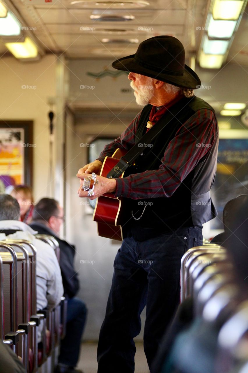 Cowboy laying guitar on train Grand Canyon railroad 
